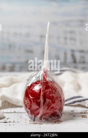 Apple candy or red toffee. Candy apples with syrup on a white wood background. close up Stock Photo