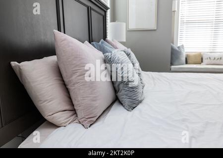 A light and bright gray master bedroom with a large king sized comfortable bed Stock Photo