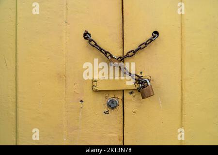 chain lock on the wooden yellow door. copy space Stock Photo