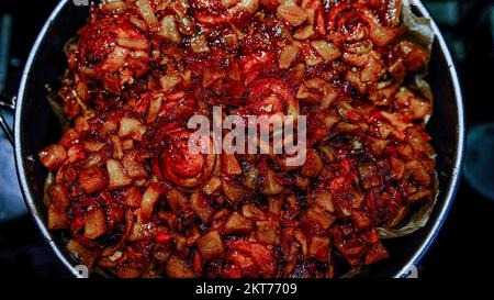 Homemade red tasty apple pie on a dark stove background in baking circle Stock Photo
