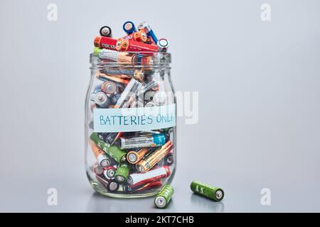 Jar filled with discharged used batteries. Waste disposal and recycling. Separating the waste. Batteries only container Stock Photo