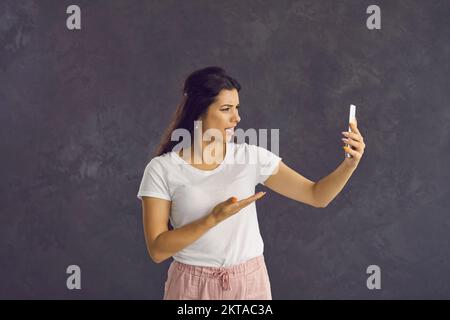 Young Latin woman feel distressed talking on cellphone Stock Photo