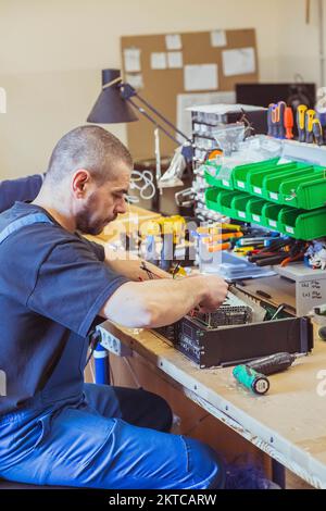 The worker assembles the amplifier to the speaker system Stock Photo