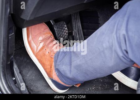 Pressing the clutch in the car, Foot pressing the pedal, Starting the car Stock Photo