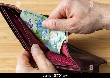 Hand takes money out of wallet, Romania banknotes, Economic and financial concept, rising prices, value of Romanian leu Stock Photo