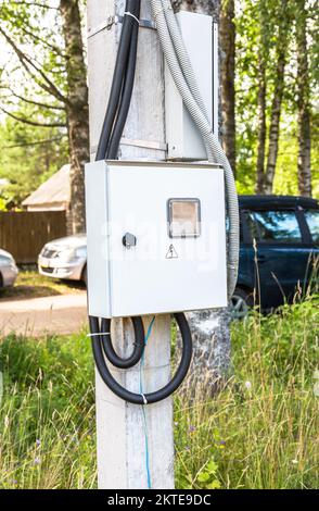 Electrical distribution board on a power line support in summer. Electrical junction box on the post Stock Photo