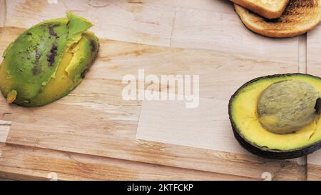 Fresh Avocado sliced over vintage wooden background close up. Ripe green avocado fruit on wood board. Stock Photo