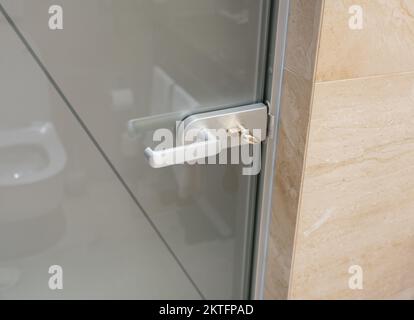 Metal handle in the glass door of the toilet of a modern hotel Stock Photo