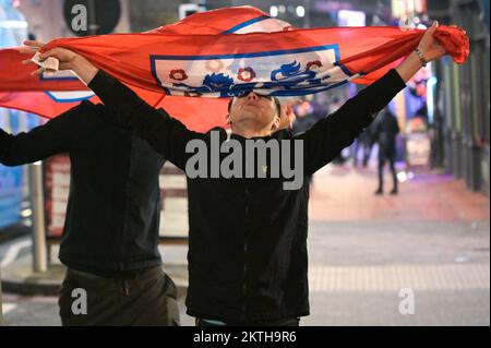 Broad Street, Birmingham, November 29th 2022 - Two England Fans walk joyously home with flags on Broad Street in Birmingham after England beat Wales 3-0 in the World Cup on Tuesday night. Pic by Credit: Stop Press Media/Alamy Live News Stock Photo