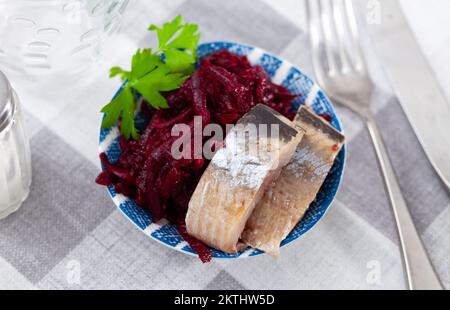 Sliced herring with grated beetroot served on table Stock Photo