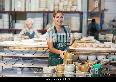 Cheerful young woman ceramist in workshop Stock Photo