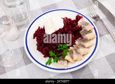 Sliced herring with grated beetroot served on table Stock Photo