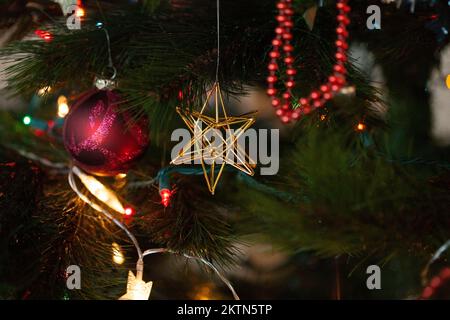 A Christmas tree decorations background has colorful lights and ornaments. Stock Photo