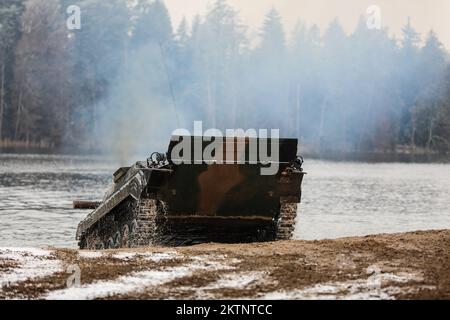 Polish soldiers assigned to 20th Mechanized Brigade operating a BMP-1 conduct amphibious assault operations during the Bull Run training exercise at Bemowo Piskie, Poland, Nov. 25, 2022. The 20th Mechanized Brigade is proudly working alongside the 1st Infantry Division, NATO allies and regional security partners to provide combat-credible forces to V Corps, under America's forward deployed corps in Europe. (U.S. Army National Guard photo by Sgt. Gavin K. Ching) Stock Photo