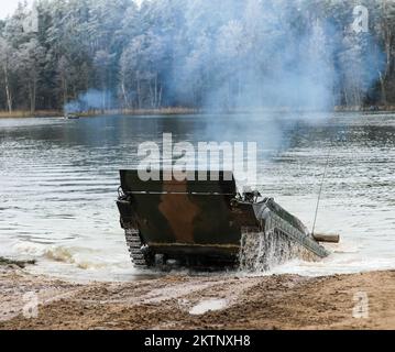 Polish soldiers assigned to 20th Mechanized Brigade operating a BMP-1 conduct amphibious assault operations during the Bull Run training exercise at Bemowo Piskie, Poland, Nov. 24, 2022. The 20th Mechanized Brigade is proudly working alongside the 1st Infantry Division, NATO allies and regional security partners to provide combat-credible forces to V Corps, under America's forward deployed corps in Europe. (U.S. Army National Guard photo by Sgt. Gavin K. Ching) Stock Photo