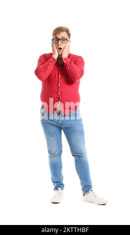 Shocked young overweight man in tight shirt on white background Stock Photo