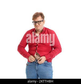 Young overweight man in tight shirt and jeans on white background Stock Photo