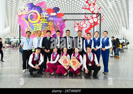SHENZHEN, CHINA - FEBRUARY 16, 2015: China Southern Airlines crew members posing in airport. China Southern Airlines Company Limited is an airline hea Stock Photo