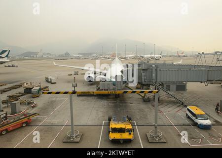 HONG KONG - MARCH, 09, 2015: Cathay Pacific aircraft near boarding bridge. Cathay Pacific is the flag carrier of Hong Kong, with its head office and m Stock Photo