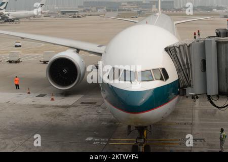 HONG KONG - MARCH, 09, 2015: Cathay Pacific aircraft near boarding bridge. Cathay Pacific is the flag carrier of Hong Kong, with its head office and m Stock Photo