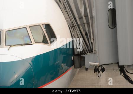 HONG KONG - MARCH, 09, 2015: Cathay Pacific aircraft near boarding bridge. Cathay Pacific is the flag carrier of Hong Kong, with its head office and m Stock Photo