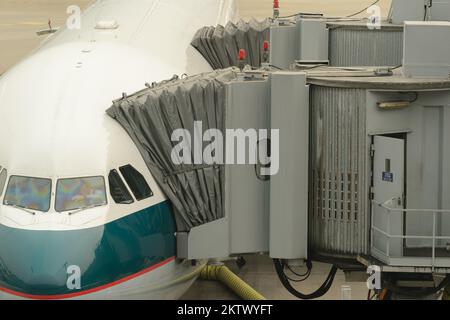 HONG KONG - MARCH, 09, 2015: Cathay Pacific aircraft near boarding bridge. Cathay Pacific is the flag carrier of Hong Kong, with its head office and m Stock Photo