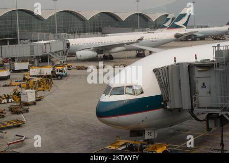 HONG KONG - MARCH, 09, 2015: Cathay Pacific aircraft near boarding bridge. Cathay Pacific is the flag carrier of Hong Kong, with its head office and m Stock Photo