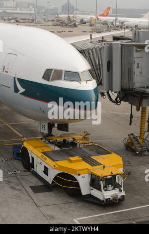 HONG KONG - MARCH, 09, 2015: Cathay Pacific aircraft near boarding bridge. Cathay Pacific is the flag carrier of Hong Kong, with its head office and m Stock Photo