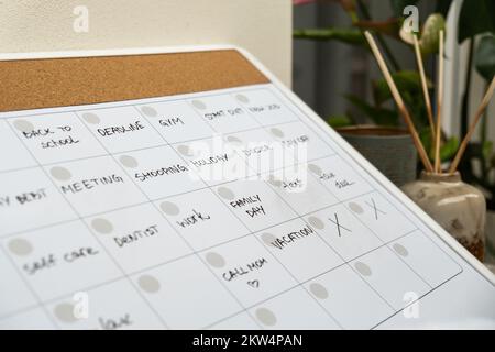 Monthly PLANNER filled with appointments and plans for next month. Busy month schedule. Magnetic board with the days of the month. Place to enter important matters schedule. Concept for business planning. Whiteboard Planner magnetic monthly template. Interior of freelancer workplace  Stock Photo