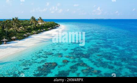 Aerial view bird's eye view of left long beach palm beach of Maldives island, in the middle lagoon with coral blocks of stony corals (Scleractinia), F Stock Photo