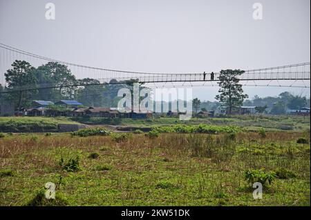 People crossing a hanging bridge in Chitwan National Park, Nepal Stock Photo