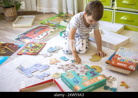 Khabarovsk, Russia - 13, September, 2022. Male kid assembling puzzle details collect mosaic Stock Photo