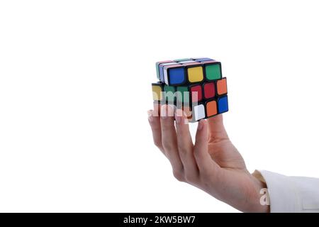 Child holding a Rubik's cube in hand on a white background Stock Photo