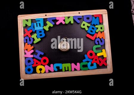 Pocket watch and colorful Letters of Alphabet made of wood Stock Photo