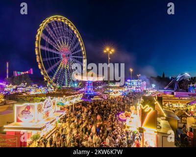 Ferris wheel, chain carousel and other rides and stalls at the Cannstatter Volksfest at night, Cannstatter Wasen, Bad Cannstatt, Stuttgart, Baden-Würt Stock Photo