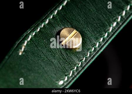 Part of a leather product or belt in green on a black background. Stock Photo