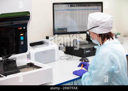 Belarus, Gomil, May 31, 2021. City Central Hospital.Doctor laboratory assistant examines biochemical analyzes at a computer monitor. Stock Photo