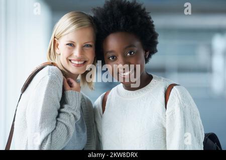 We take all our classes together. Two young college students standing together and smiling. Stock Photo