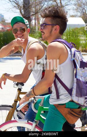 Hey, whatsup. two young guys sitting on their bikes outdoors. Stock Photo
