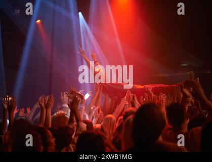 Surfing on a crowd of fans. A stage diver being carried across the audience at a rock concert. Stock Photo