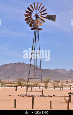 wind Pump in Namibia desert Africa Blue Sky Mountains Wind energy Stock Photo