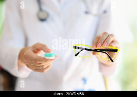 Ophthalmologist doctor holds glasses and contact lenses in his hands close-up. Stock Photo