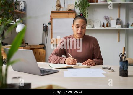 Portrait of multiethnic female artist working on new designs in studio Stock Photo