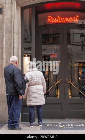 Barcelona, Spain - Dec 29th 2019: Elderly couple of tourists reading Parellada restaurant menu. Gothic Quarter, Catalonia, Spain Stock Photo