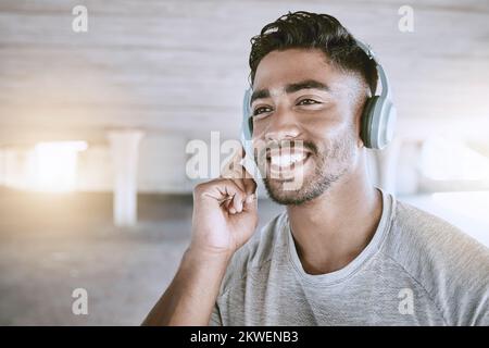 Workout music, fitness headphones or digital radio. Music technology device plays music, smiling relaxed indian man listening to audio sound earphone Stock Photo