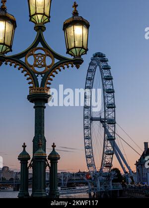 London Eye with street lamps on Westminster Bridge, London, England Stock Photo