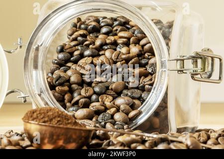 Overturned coffee beans from a tin and a copper meter with ground coffee Stock Photo
