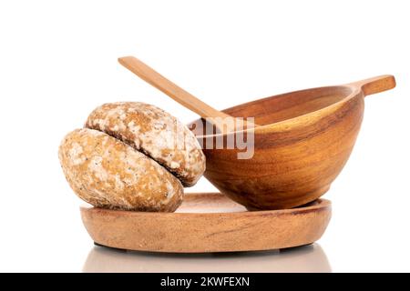 Two sweet delicious gingerbread cookies with a wooden cup on a wooden plate, macro, isolated on white background. Stock Photo