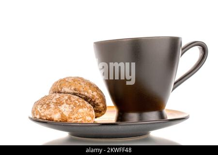 Two sweet delicious gingerbread cookies with black ceramic cup on ceramic plate, macro isolated on white background. Stock Photo