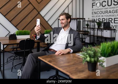 successful businessman in the office communicates via video call using the phone Stock Photo